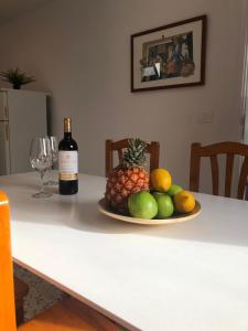 una botella de vino y un plato de fruta en una mesa en Villas Yaiza. El Golfo, en El Golfo