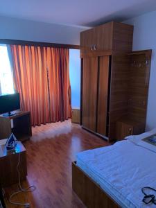 sypialnia z dużym łóżkiem i drewnianymi meblami w obiekcie HOTEL modern / Imobiliare Garcea Titu w mieście Titu