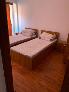 HOTEL modern / Imobiliare Garcea Titu في Titu: سريرين في غرفة صغيرة مع أرضيات خشبية