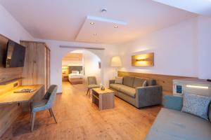 ein Wohnzimmer mit einer Couch und einem Tisch in der Unterkunft Hotel Luggi in Galtür