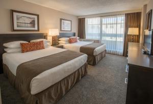 a hotel room with two beds and a television at The Embassy Inn in Victoria
