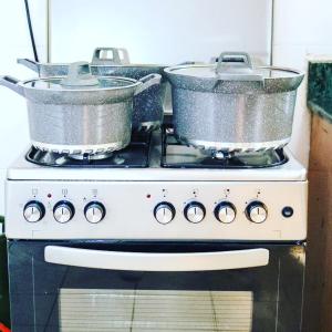 two pots sitting on top of a stove at Sofitel 4 bedrooms maisonette Milimani in Kisumu