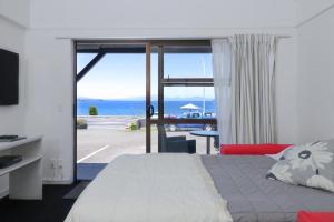a bedroom with a bed and a view of the ocean at Gables Lakefront Resort in Taupo