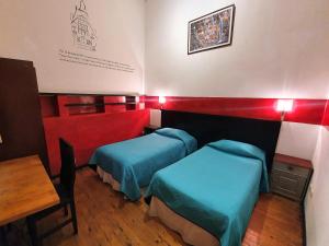 Habitación con 2 camas y mesa. en Maki Suites ex Hotel Da Vinci, en Valparaíso