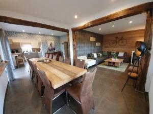 a dining room and living room with a wooden table and chairs at Gite le Ravel in Hockai