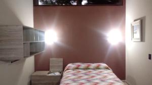 a bedroom with a bed and lights on the wall at Entre Gaviotas in Las Gaviotas