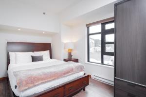 um quarto com uma cama grande e uma janela em Carleton Lodge by Outpost Whistler em Whistler