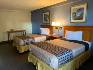 a hotel room with two beds and two lamps at Knights Inn - Lithonia in Lithonia