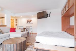 a bedroom with a bed and a couch and a table at Carleton Lodge by Outpost Whistler in Whistler