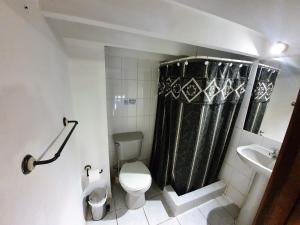 a bathroom with a toilet and a black shower curtain at Maki Suites ex Hotel Da Vinci in Valparaíso