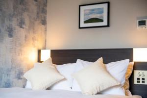 a bedroom with a bed with white pillows at KOKO HOTEL Sapporo Odori in Sapporo