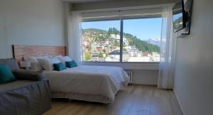 a bedroom with two beds and a large window at CONDOR STUDIO BARILOCHE in San Carlos de Bariloche +20 photos