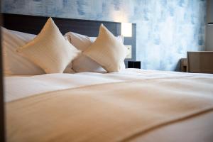 a large white bed with white pillows at KOKO HOTEL Sapporo Odori in Sapporo