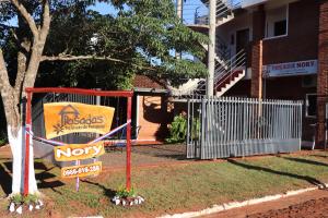 una señal para un motel frente a un edificio en Posada Turística Nory, en Encarnación