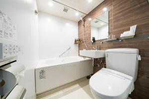 a bathroom with a white toilet and a sink at KOKO HOTEL Sapporo Odori in Sapporo