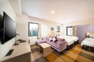 a hotel room with a bed and a tv at KOKO HOTEL Sapporo Odori in Sapporo