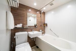 a bathroom with a sink and a toilet and a tub at KOKO HOTEL Sapporo Odori in Sapporo +31 photos