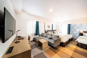 um quarto de hotel com uma cama e um sofá em KOKO HOTEL Sapporo Odori em Sapporo