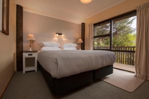 ein Schlafzimmer mit einem Bett und einem großen Fenster in der Unterkunft Punga Cove Resort in Endeavour Inlet