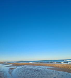 una playa de arena con el océano en el fondo en Casa Coqueta, en Almarda