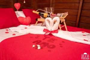 - un lit avec une bouteille de champagne et un cœur fait de serviettes dans l'établissement Pousada Sol & Sal Praia do Rosa, à Praia do Rosa 231 autres photos