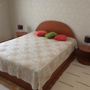 a bedroom with a bed with red and green pillows at Szundi Szob&aacute;k in P&eacute;cs