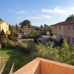 Blick auf einen Garten mit Palmen und Gebäuden in der Unterkunft Mini villa Messicana 5 pers piscine 500 m plage in Lecci