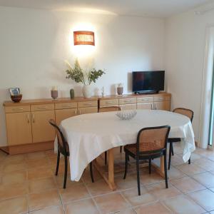 a dining room with a white table and chairs at Mini villa Messicana 5 pers piscine 500 m plage in Lecci