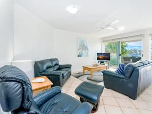 a living room with leather furniture and a tv at Blue Pacific 2 in Yamba