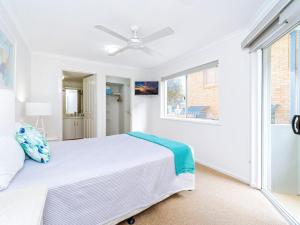 a white bedroom with a bed and a window at Blue Pacific 2 in Yamba