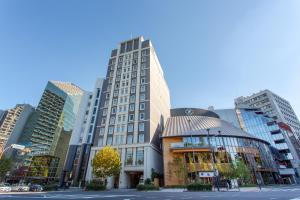 ein hohes Gebäude mitten in einer Stadt in der Unterkunft Hotel Monterey Akasaka in Tokio