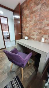 una mesa y una silla púrpura en una habitación en R08 LUXURY STUDIO RAISE a 5 MIN DEL ITESM R08, en Ciudad de México