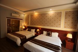 een hotelkamer met 2 bedden en 2 lampen bij Sapa Unique Hotel in Sa Pa