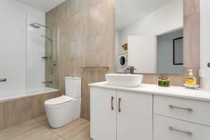 un bagno bianco con lavandino e WC di Seascape Holidays at Beaches Port Douglas a Port Douglas