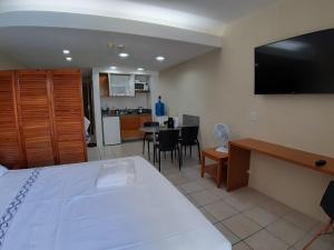 una camera da letto con un letto e una cucina con un tavolo di Flat beira mar, Olinda 4 Rodas 305 a Olinda