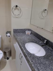 un bagno con lavandino, WC e specchio di Flat beira mar, Olinda 4 Rodas 305 a Olinda