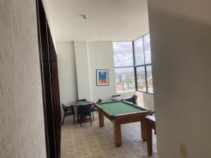 una stanza con tavolo da ping pong e sedie di Flat beira mar, Olinda 4 Rodas 305 a Olinda
