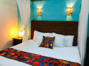 ein Schlafzimmer mit zwei weißen Betten und einer blauen Wand in der Unterkunft El Roble Nature Hotel & Lagoon in Bacalar