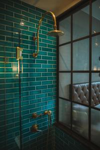 La salle de bains est pourvue d'un mur carrelé bleu et d'une douche. dans l'établissement Arlo Williamsburg, à Brooklyn