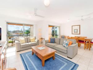 a living room with a couch and a table at Beach Break in Yamba