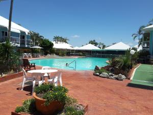 a pool with a table and chairs in a resort at JAROLIFE4 Room 135 in Eimeo