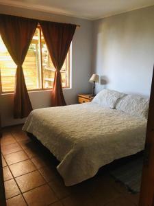 a bedroom with a large bed and a window at Alto Curanipe in Pelluhue