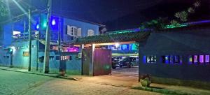 a city street at night with a blue building at Pousada e Condominio Miragem Do Mar Praia Do Peró in Cabo Frio