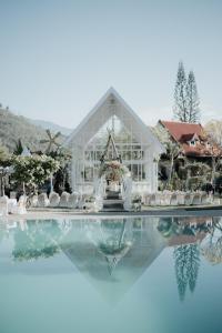a wedding in a glass house with a reflection in the water at Royal Orchids Garden Hotel & Condominium in Batu