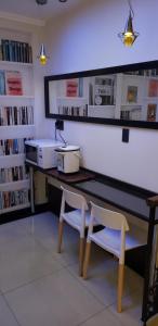 einen Schreibtisch mit zwei Stühlen in einer Bibliothek mit Büchern in der Unterkunft Sur Hotel in Montevideo