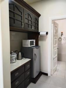 a small kitchen with a microwave and a refrigerator at Bourbon St Apts Condo 30C in Angeles