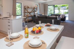 a kitchen and living room with a table with food and drinks at Rolki House - Hanmer Springs Holiday Home in Hanmer Springs