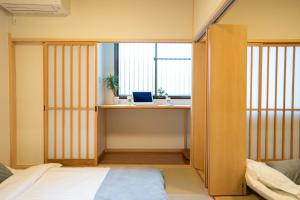 a bedroom with a bed and a laptop on a desk at 大吉屋2号館 ワンフロア貸切部屋 名駅離れ in Nagoya