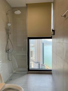 a bathroom with a window with a view of the ocean at Wise Stay Scenia Bay Apartment in Nha Trang