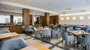 ein Restaurant mit Tischen und Stühlen und eine Bar in der Unterkunft MODERNO Hotel in Taschkent